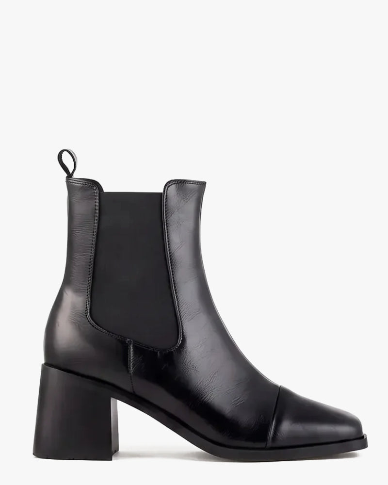 A black leather Chelsea-style ankle boot with a block heel and elastic side gore, shown in profile against a plain white background.